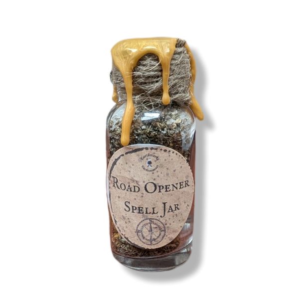 Glass jar labeled 'Road Opener Spell Jar' with a string and yellow wax on a white background