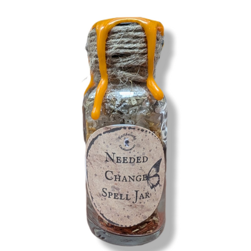 Small glass jar with a label reading 'Needed Change Spell Jar' on a white background