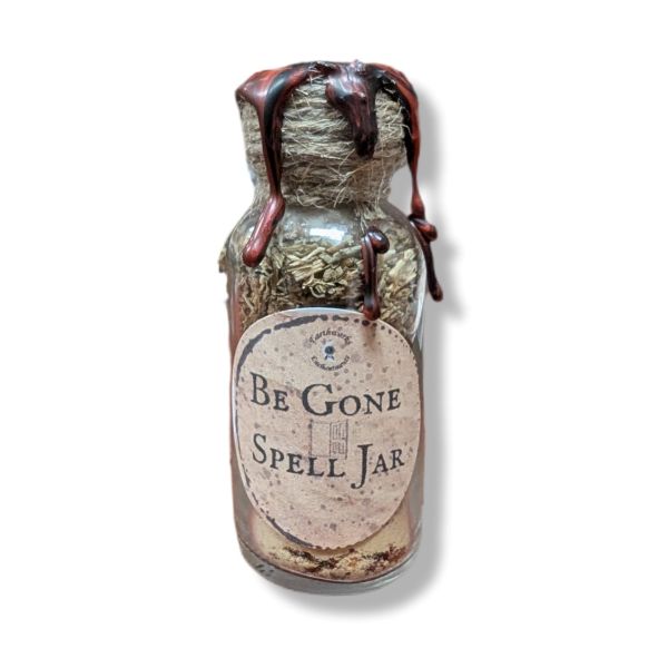 Spell jar labeled 'Be Gone Spell Jar' with herbs and a label on a white background