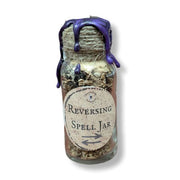 Glass jar labeled 'Reversing Spell Jar' with purple wax on a white background