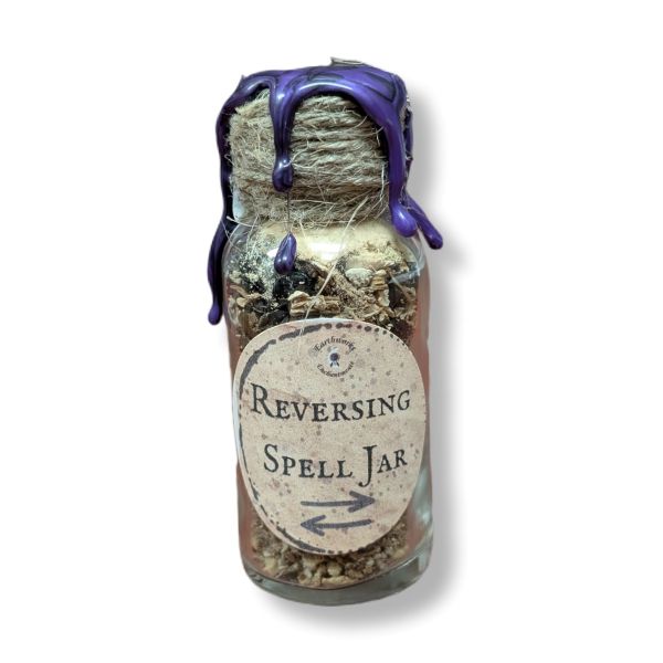 Glass jar labeled 'Reversing Spell Jar' with purple wax on a white background