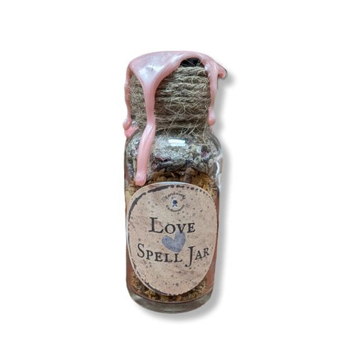 Small glass jar labeled 'Love Spell Jar' with a pink wax on a white background