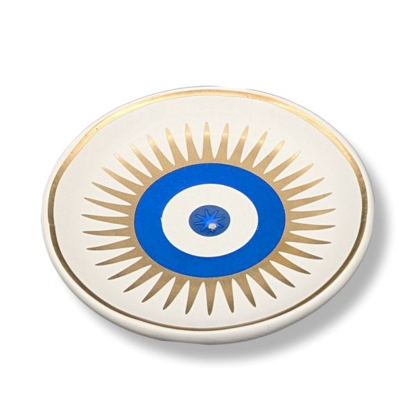 Decorative plate with blue center and gold sunburst pattern on a white background
