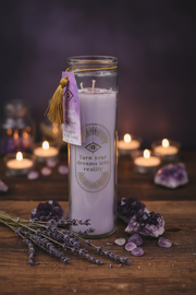 Purple candle with a message on a wooden surface with lavender and crystals.