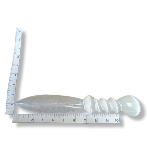 Decorative white selenite knife with a ruler for scale on a white background