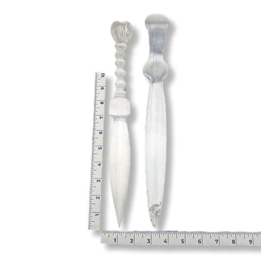 Two decorative selenite knives with a ruler for scale on a white background