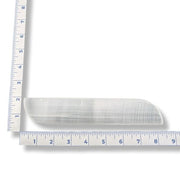 Selenite slab with a ruler for scale on a white background