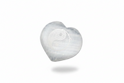 A selenite heart with a etched yin yang, on a white background