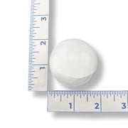 White spherical selenite next to a ruler on a white background