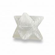 A white geometric star-shaped crystal cluster, resembling a tetrahedron with six-pointed star facets, shown on a clean white background with a soft shadow.