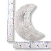 Moon-shaped stone with a ruler for scale on a white background