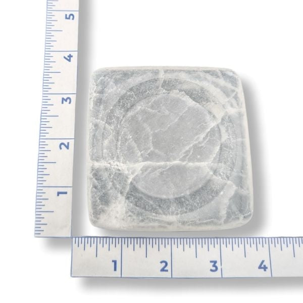 Square selenite dish with a ruler for scale on a white background
