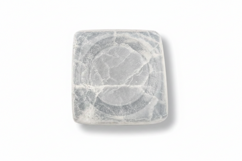 A square white selenite tray with rounded corners and a circular recessed design in the center, featuring natural gray veining, shown on a plain white background.
