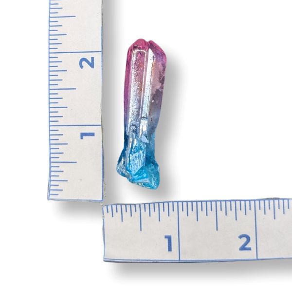 Colorful crystal next to a ruler on a white background