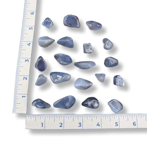 Blue stones on a white surface with a ruler for scale