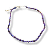 A beaded anklet featuring faceted beads that shift between deep purple and blue depending on the angle, with a silver-tone clasp, shown on a white background with a soft drop shadow.