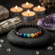 Colorful beaded bracelet on a black stone with candles and crystals in the background