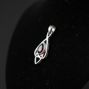 Silver pendant with a red gemstone on a black background