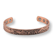 Copper bracelet with intricate designs on a white background