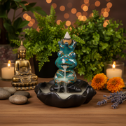 Decorative incense burner with candles, flowers, and a Buddha statue on a wooden surface.