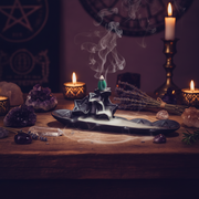 Witchcraft altar with incense, candles, and crystals on a wooden surface.
