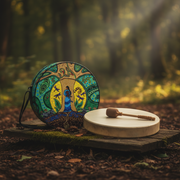 Strong Earth Woman drum bag  with a hand drum with a small mallet resting on a wooden board in an outdoor forest setting.