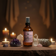 A  bottle of Earthworks Enchantments Spiritual Cleansing Room Spray stands on a wooden surface surrounded by crystals, a smudge bundle, and lit candles in a warm, atmospheric setting.