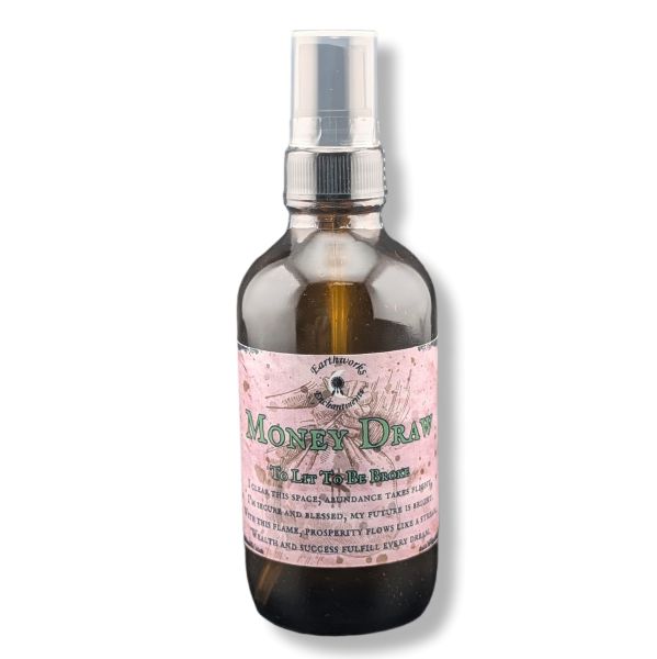 An amber glass spray bottle with a label reading 'Money Draw', shown on a white background.