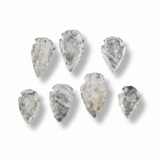 Seven raw, pointed translucent stone arrowheads with natural rough textures, arranged on a clean white background with soft drop shadows.