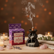 Meditation Champa incense with a smoking cone on a wooden table with candles and crystals.