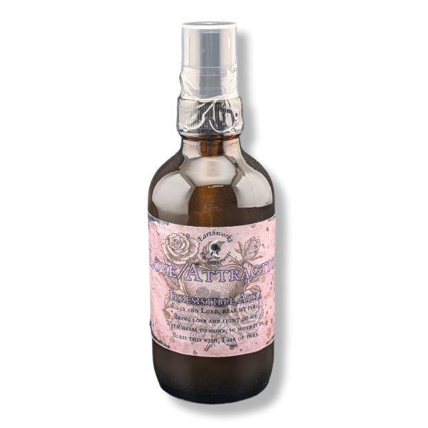 An amber glass spray bottle with a pink and white label reading 'Love/Attraction'  topped with a clear plastic spray cap, shown on a white background.