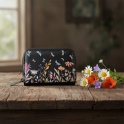 Floral-patterned wallet on a wooden surface with flowers