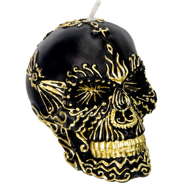 Black skull-shaped candle with gold decorative elements on a white background