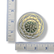 A Selenite Charge Plate with a golden Lotus Flower pattern next to a ruler for scale