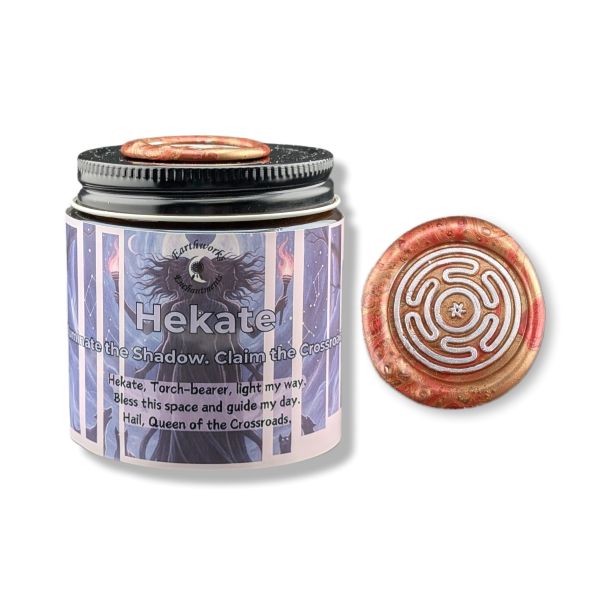 Candle jar with Hekate label and decorative lid on a white background
