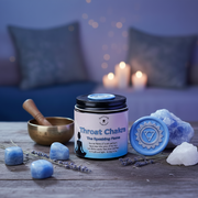 Throat Chakra product with stones, lavender, and a singing bowl on a wooden surface with a blurred candlelit background.