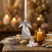 Silver angel ornament with engraved text reading 'Mom, you are my angel on Earth.' and a white ribbon loop, shown on a white background.