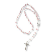 Pink pearl rosary with a silver cross on a white background