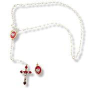 Pearl necklace with red and gold religious pendants on a white background