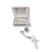 Pearl rosary with a silver cross on a white background