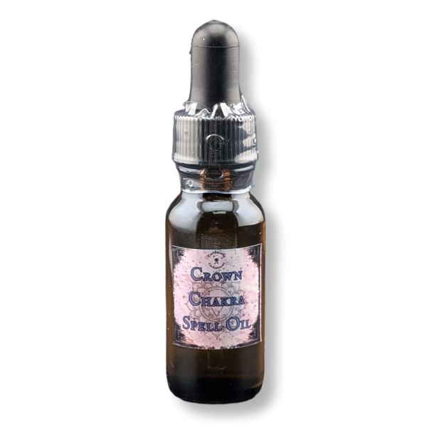 A small amber glass dropper bottle labeled 'Crown Chakra Spell Oil' with a black rubber dropper cap and a pinkish label, shown on a white background.