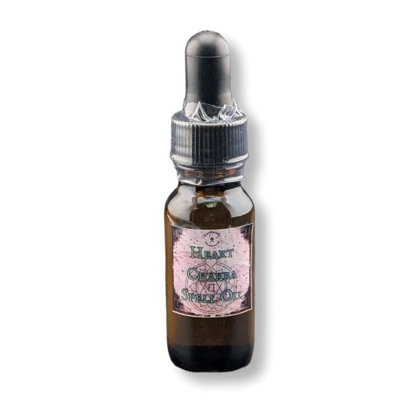 Heart Chakra spell oil in an amber dropper bottle on a white background.