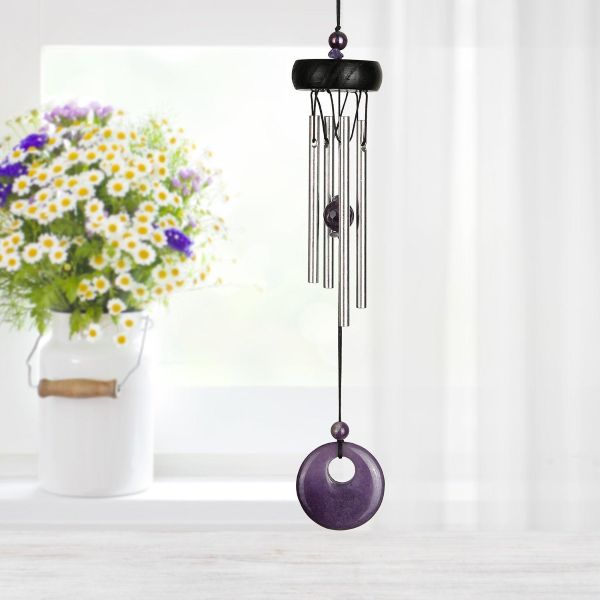 Purple wind chime with floral arrangement in the background