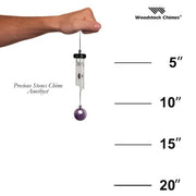 Hand holding a wind chime with measurements and Woodstock Chimes branding