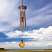 Wooden wind chime against a blue sky with clouds