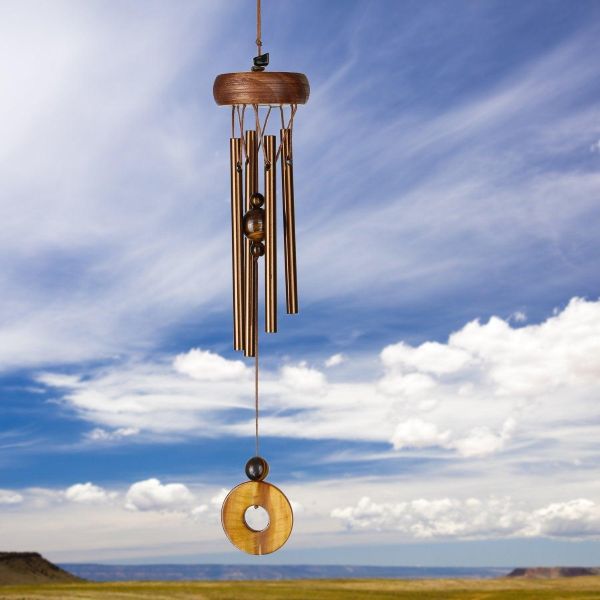 Wooden wind chime against a blue sky with clouds