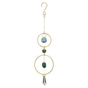 Decorative hanging ornament with gold rings, green bead, and crystal on a white background