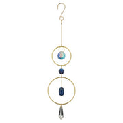 Decorative hanging ornament with gold rings, blue beads, and a crystal on a white background