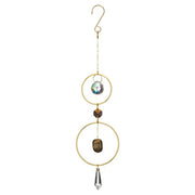 Decorative hanging ornament with gold rings, crystal, and stone on a white background