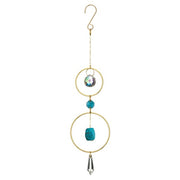 Decorative hanging ornament with gold rings, turquoise beads, and crystal accents on a white background